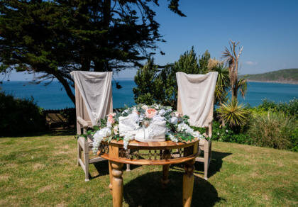 A table with two chairs and a table with flowers on it