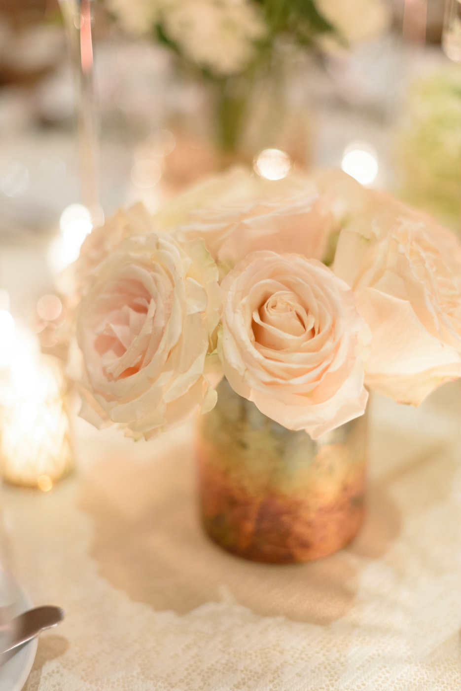 Blush garden roses in a gold vase in a simple arrangement for a sweet winter wedding.