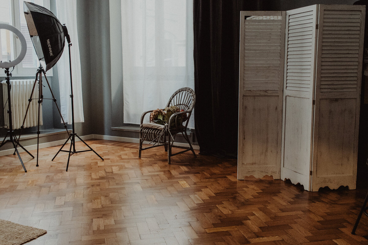 Ambiente raffinato con luce naturale, poltrona vintage e pareti color crema, perfetto per servizi fotografici boudoir di lusso