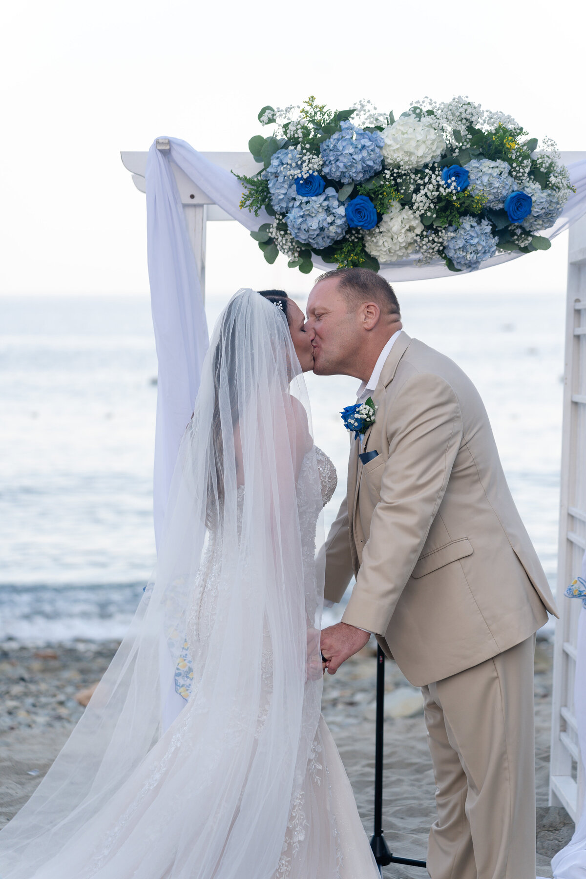 Bride and Groom eloping at Catalina Island venue Descanso Beach during elopement ceremony at sunset and kissing.