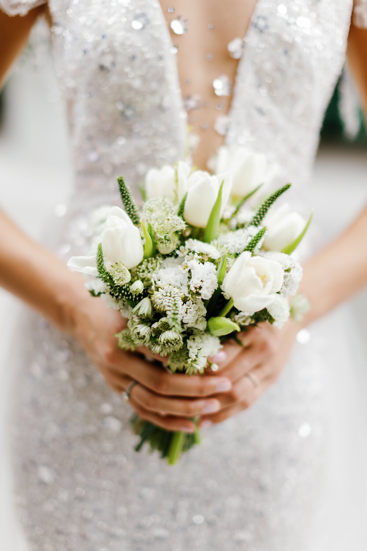 Beautiful bridal bouquet held by the bride, featuring white flowers and greenery, captured by Claudia Amalia Photography in Miami, Florida.