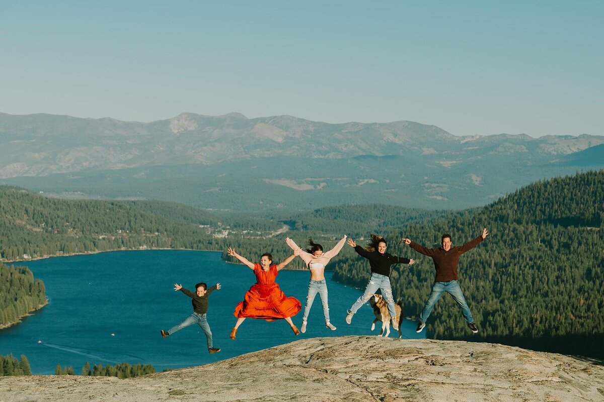 the whole family jumping up with donner lake behind them