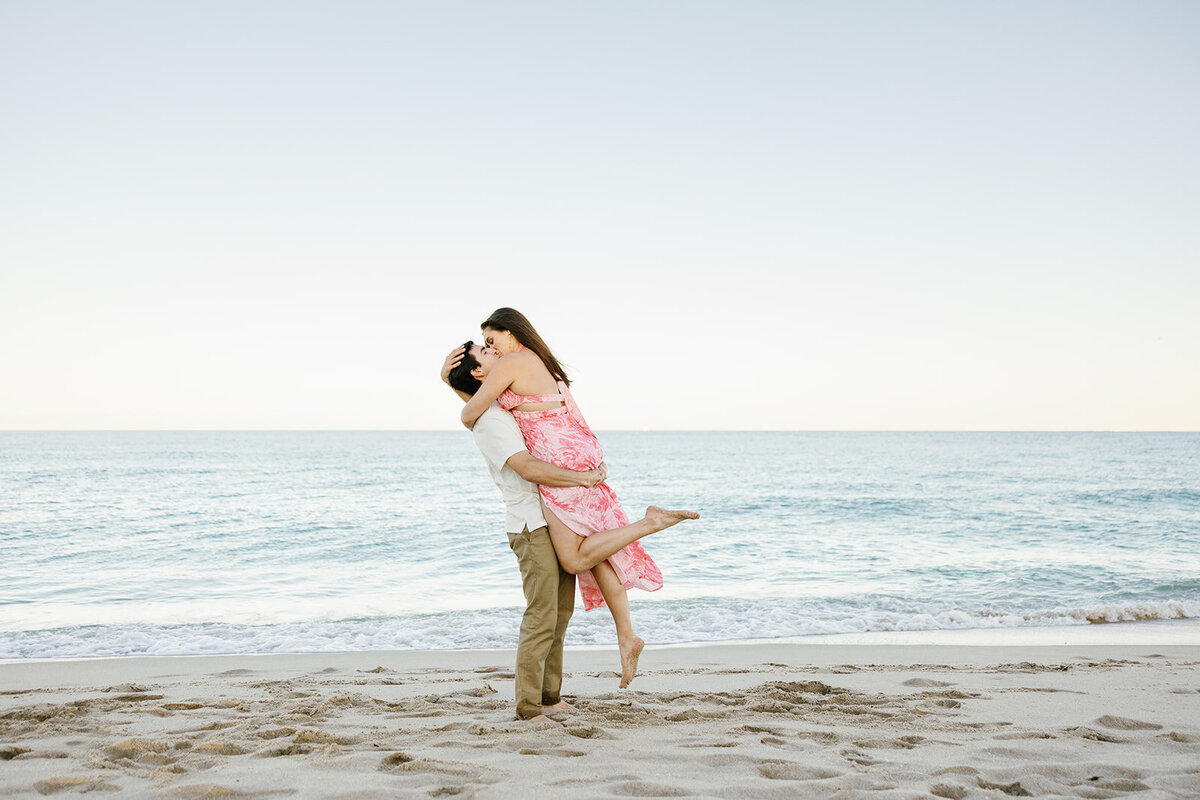 A golden sunset bathes Rebecca and Graysen in warm light as they embrace on the beach, marking a magical moment from their Florida Keys engagement session.