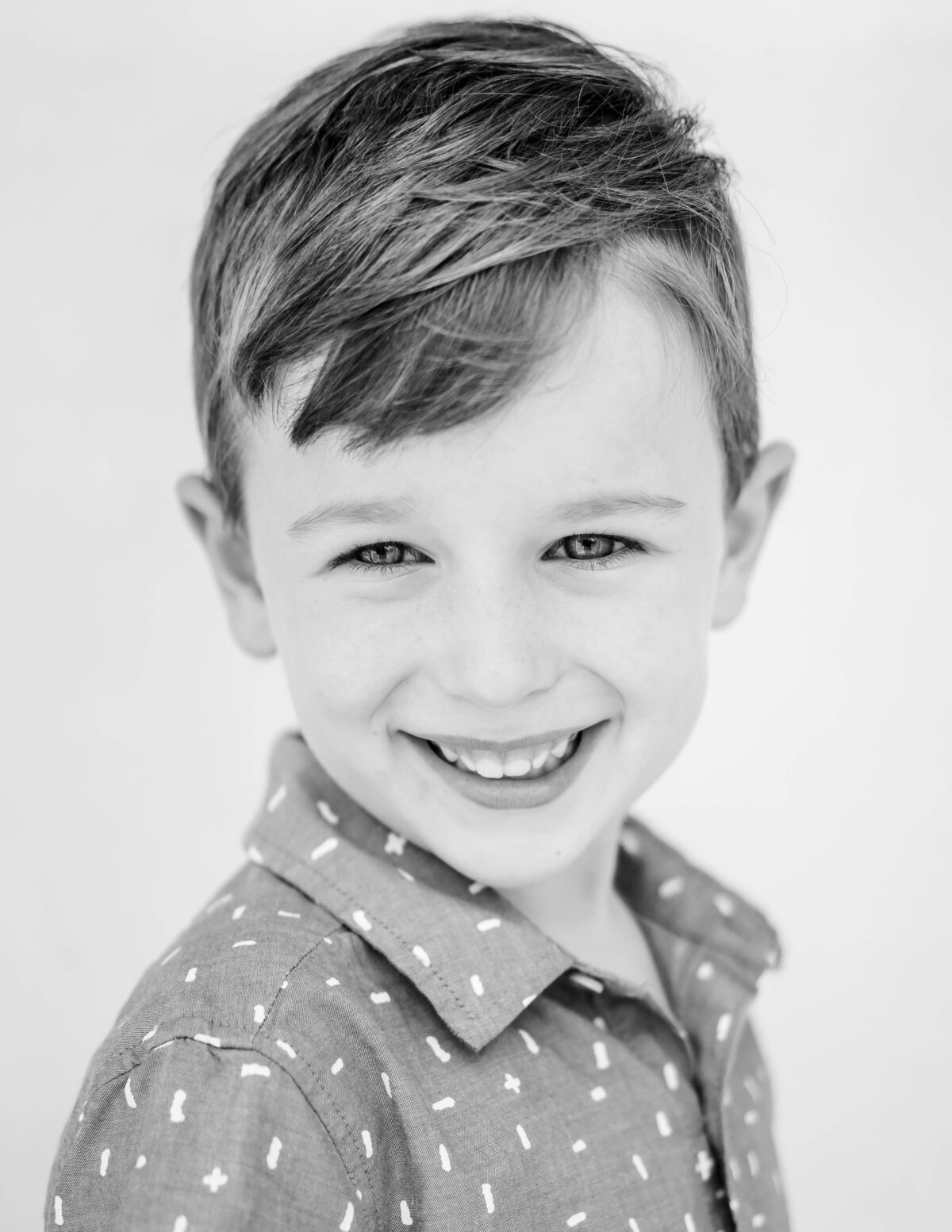 Black and white portrait of boy on white backdrop — authentic fine art school image