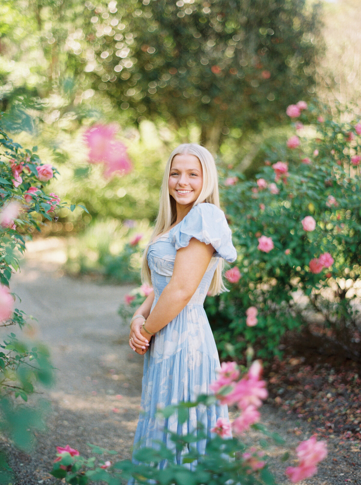 A timeless senior portrait captured among the floral splendor of Rosedown Plantation, showcasing elegance and charm on film by Morgan Alysse, Louisiana film photographer.