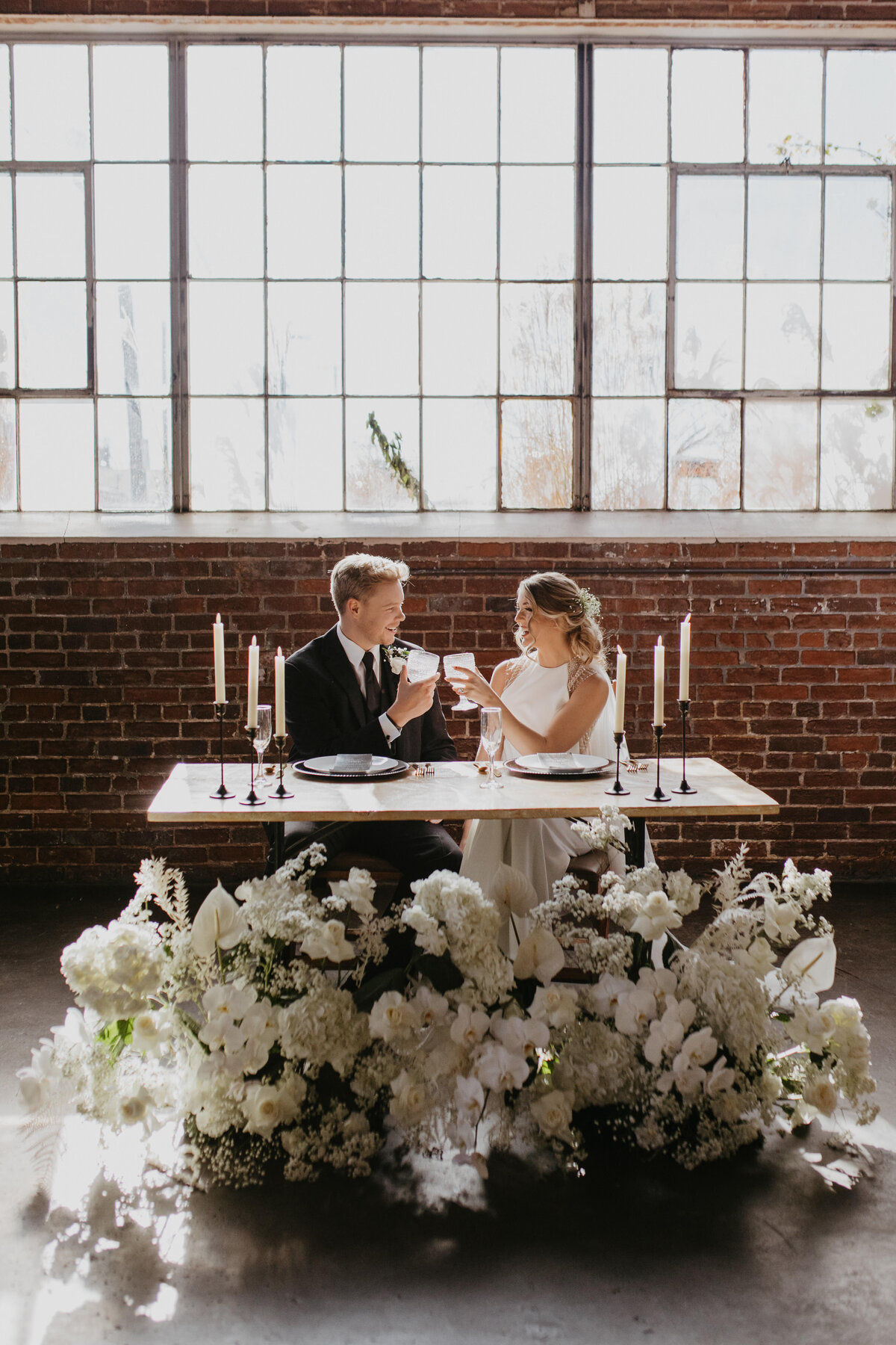 bride and groom toast at a head table
