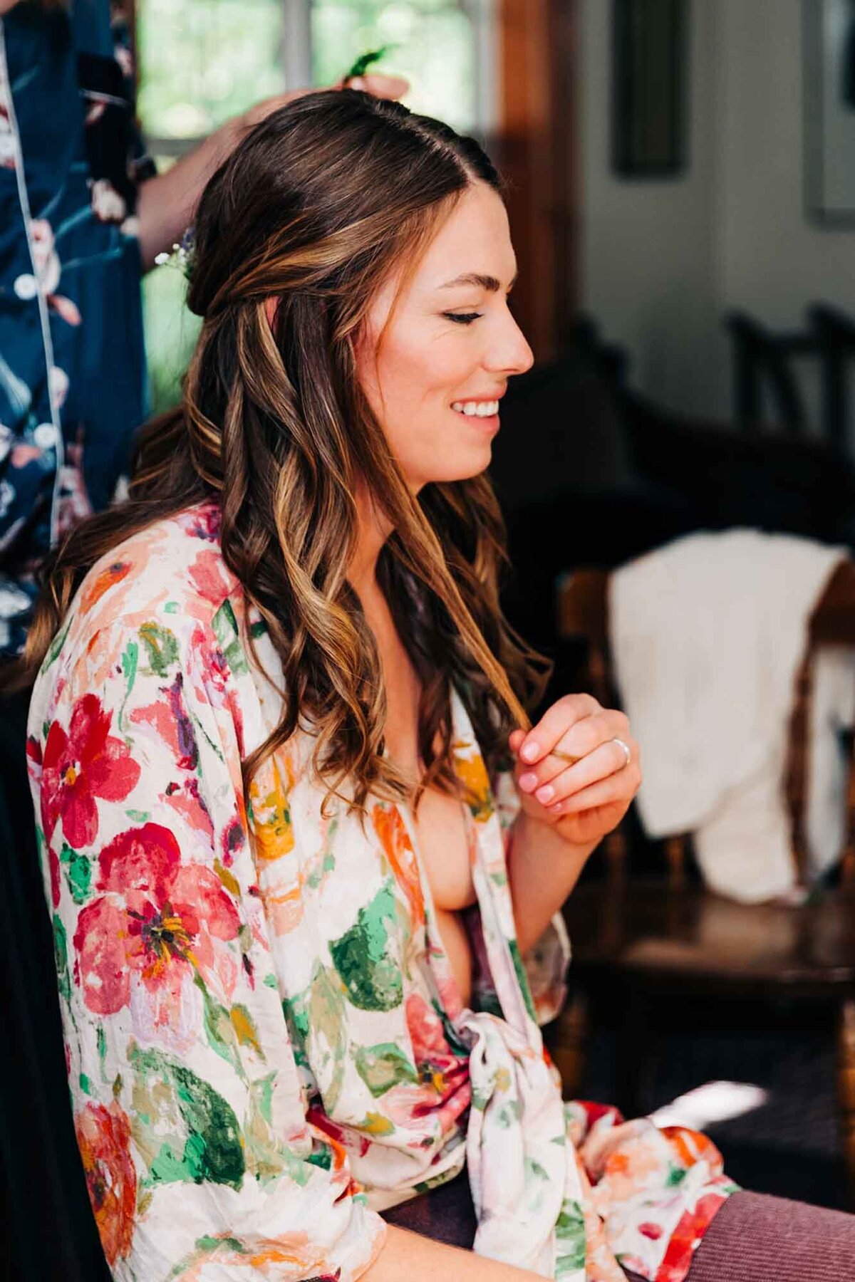 Bride getting ready in floral robe at Izaak Walton Inn, Essex, MT