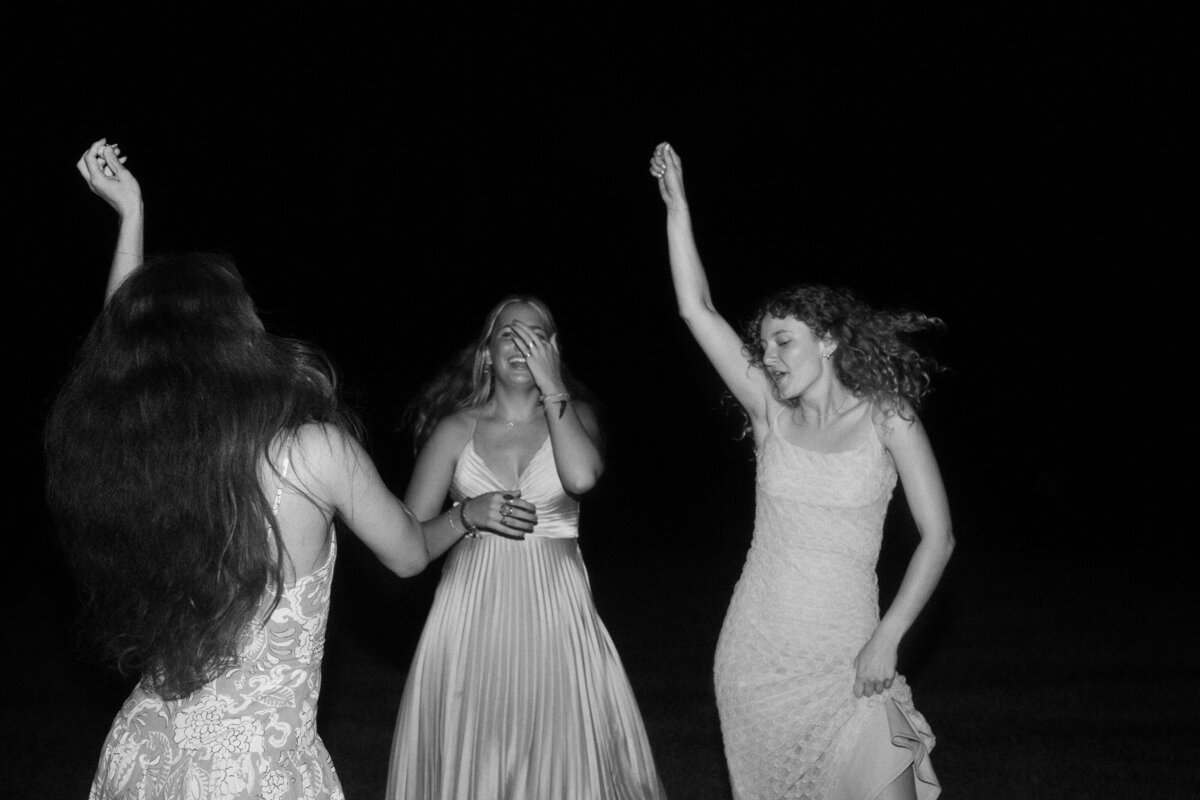 A black-and-white photograph capturing a candid laugh between guests, preserving the joy of their special day.