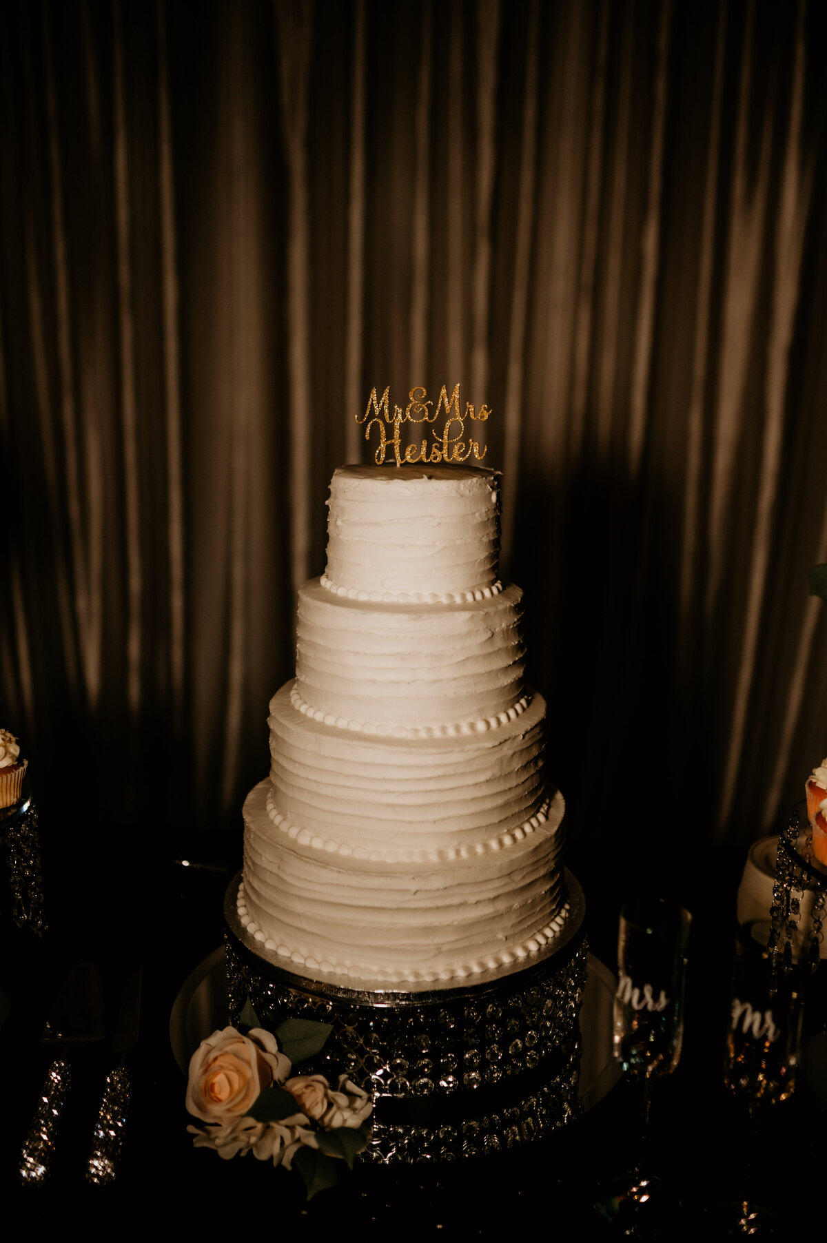 four tier white wedding cake on a crystal stand