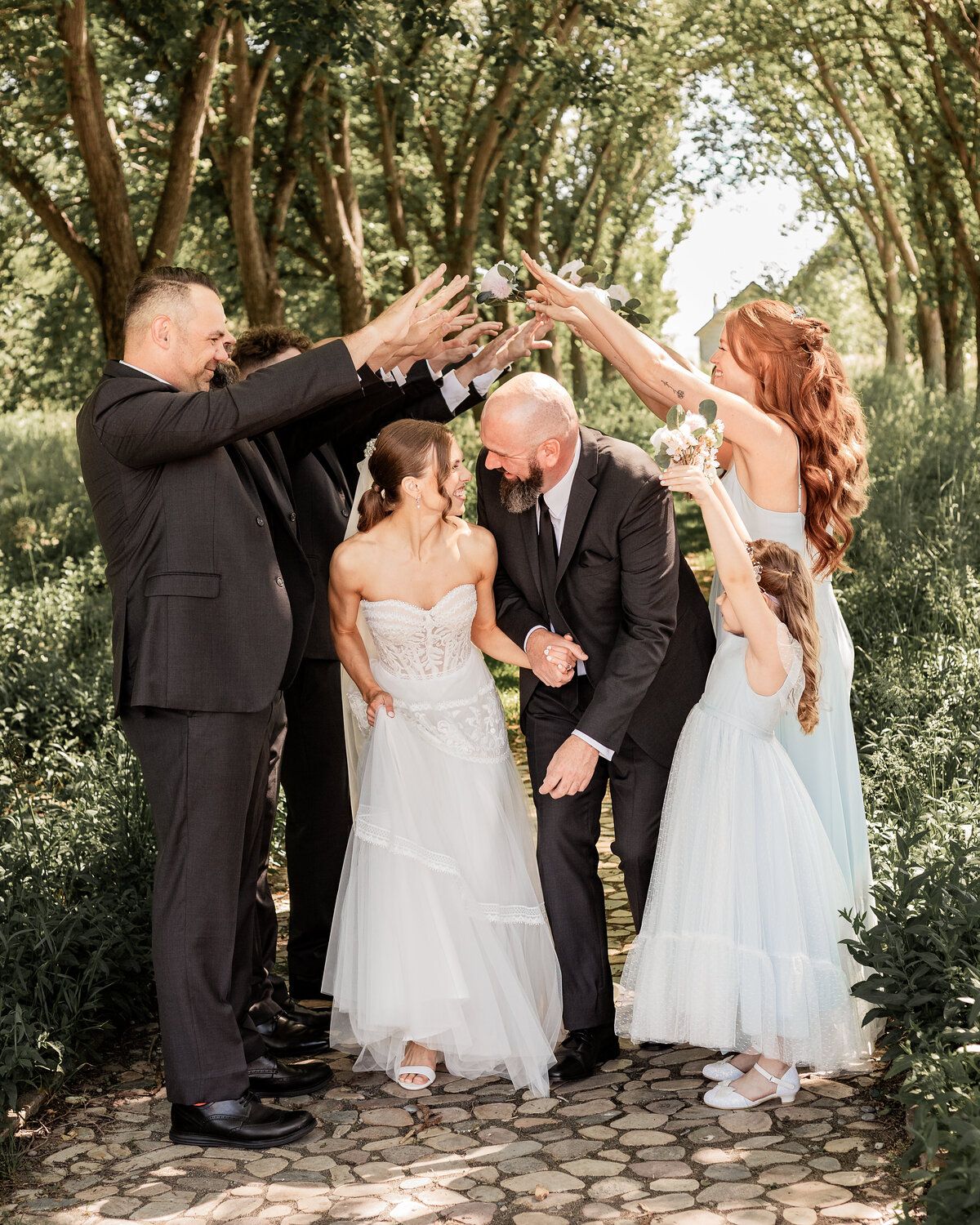 Bride and groom run through a tunnel of love made up of their wedding party