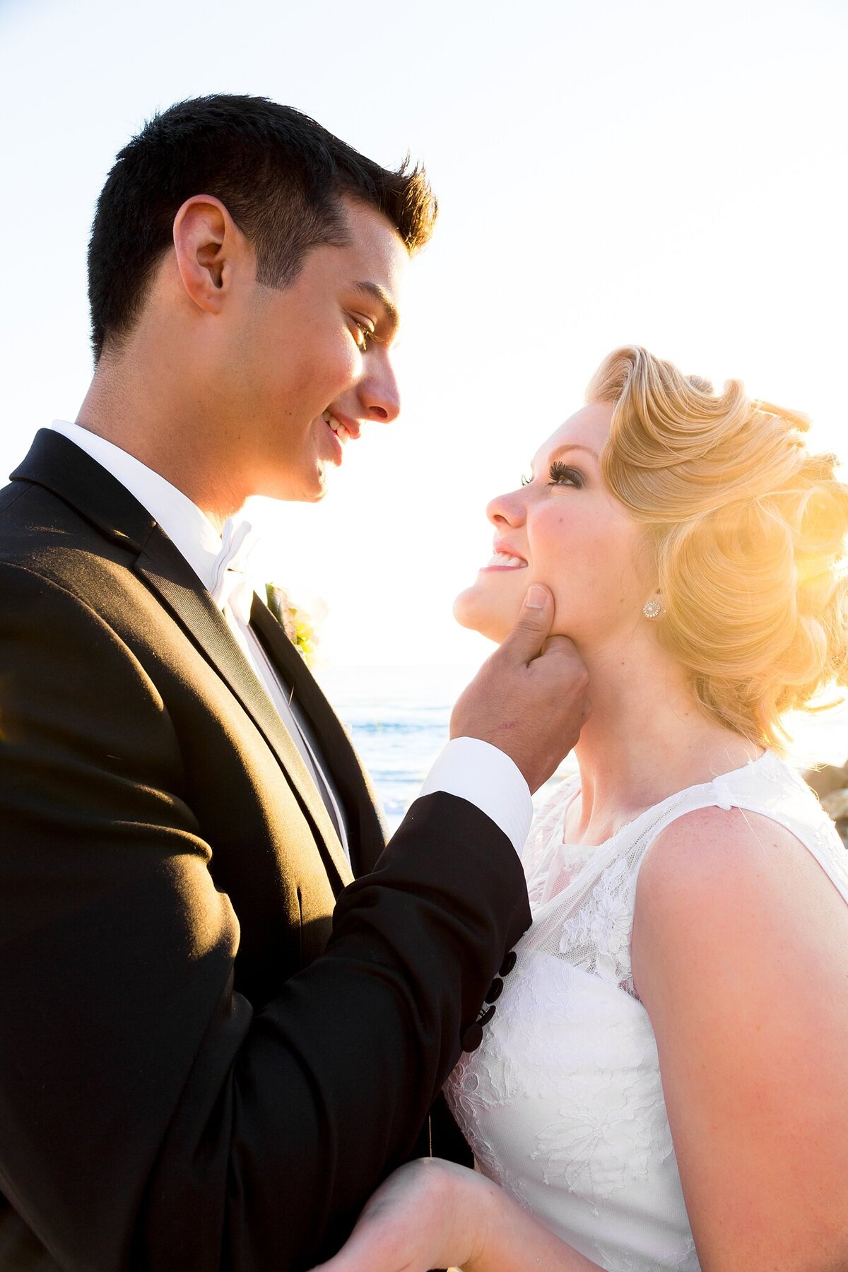 bride and groom gaze into eachothers eyes on the beach