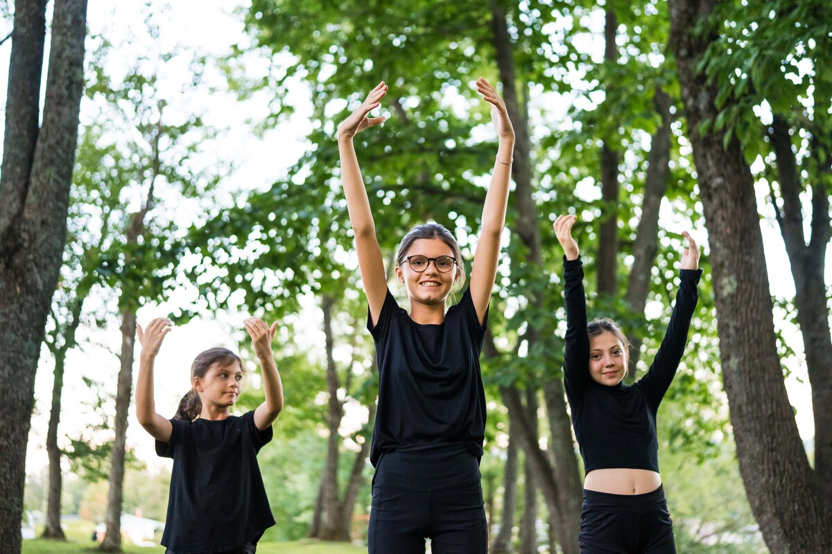 trois jeunes filles qui font une chorégraphie de danse dans la forêt