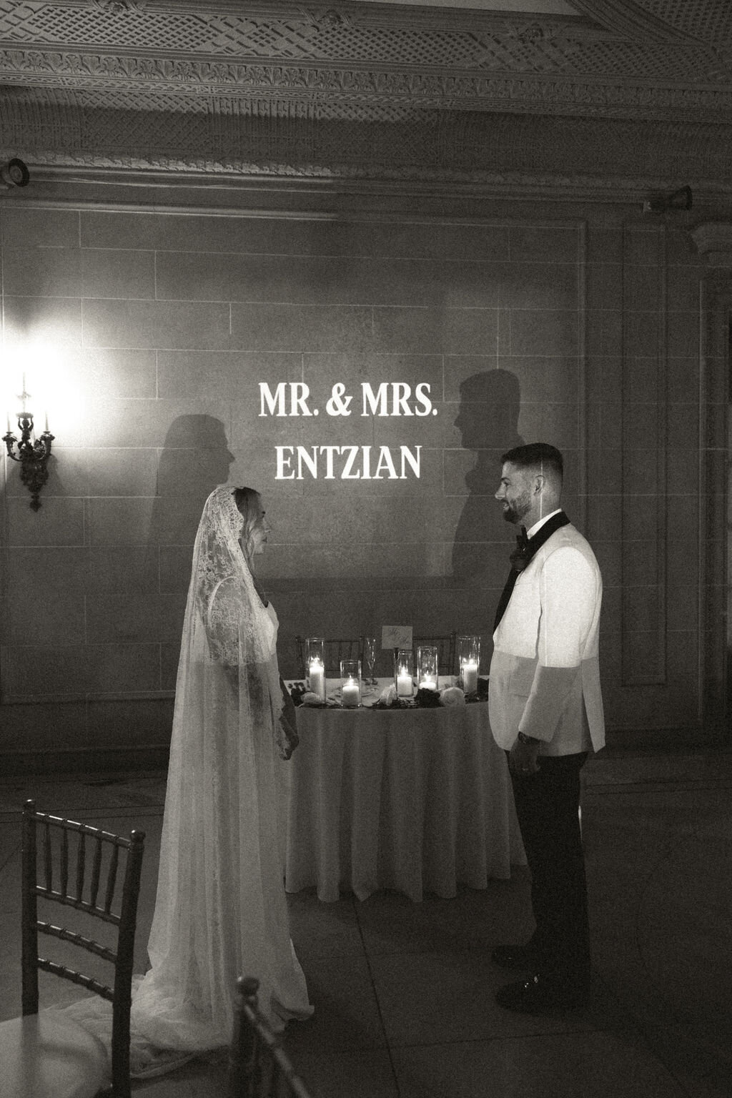 Groom hugs bride from behind and kisses her cheek