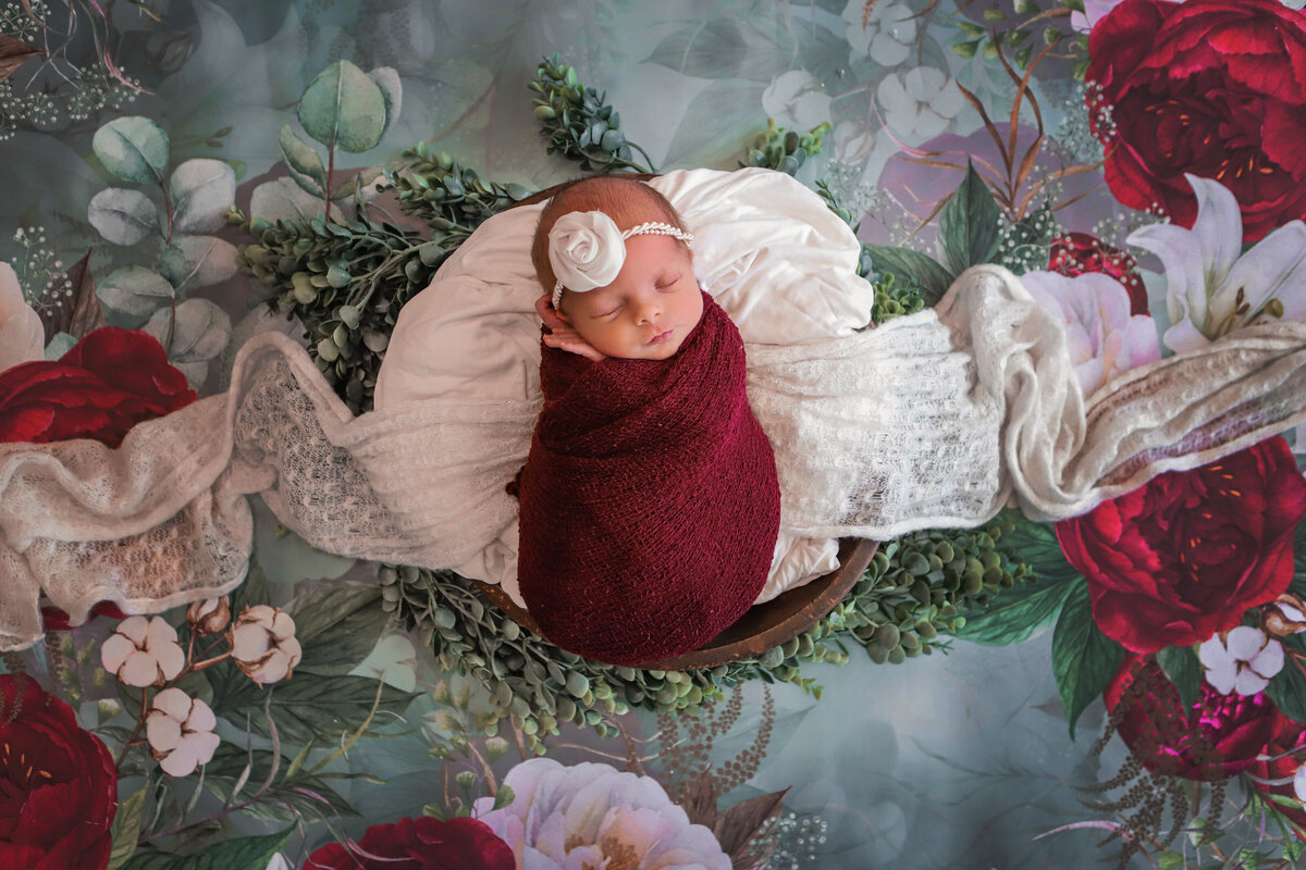 wrapped newborn on floral background