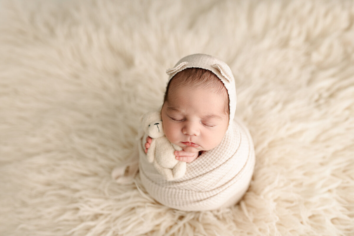 Swaddled newborn on white blanket
