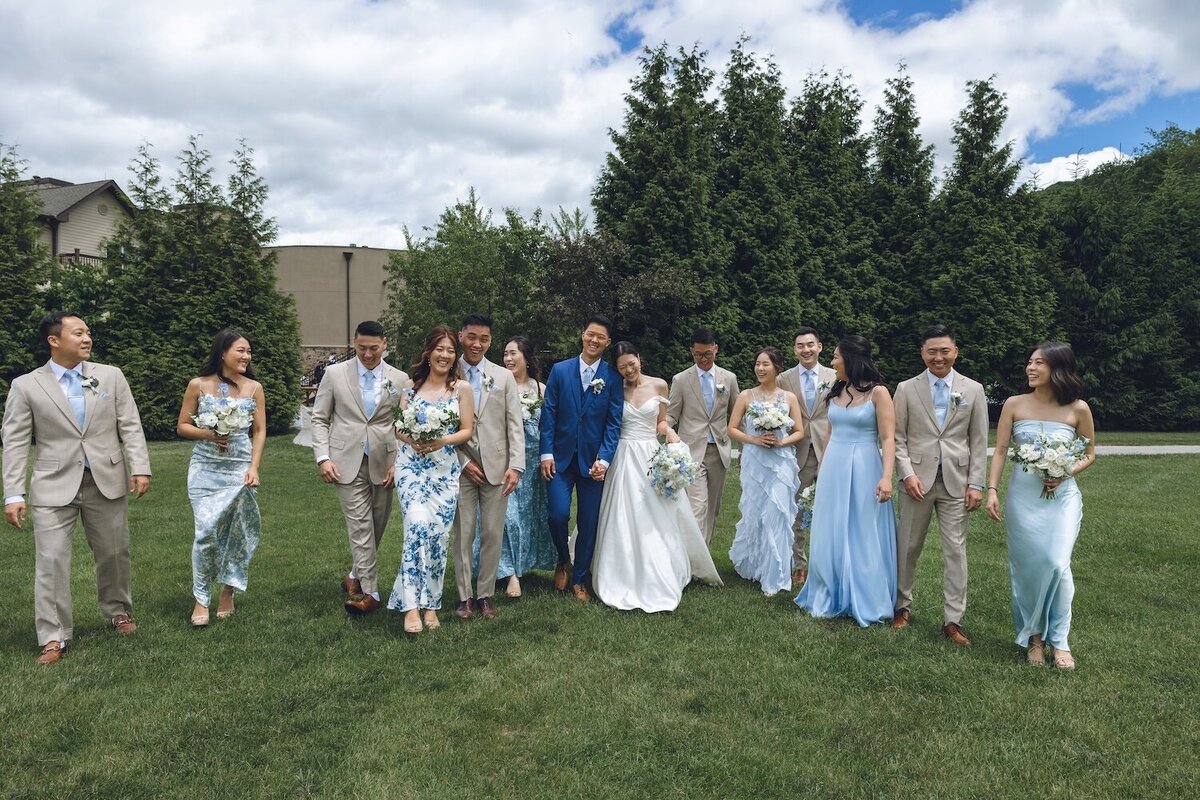 Full bridal party walking joyfully across golf course