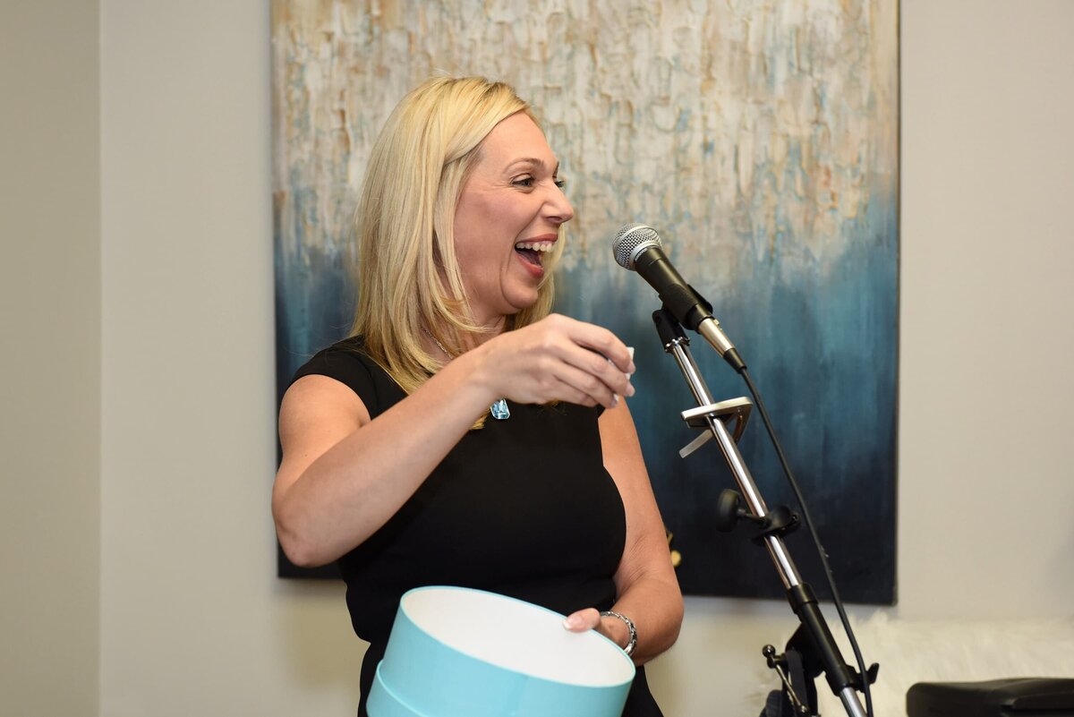 Woman speaking at a corporate networking event, smiling and engaging with the audience at a podium