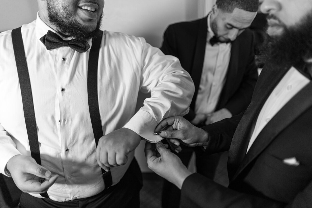 Someone putting on groom's cuff links