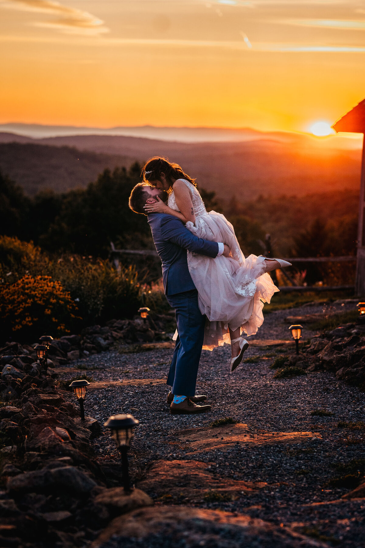 Groom lifting bride to kiss her at epic sunset at Cobb Hill Estate wedding by Lisa Smith Photography