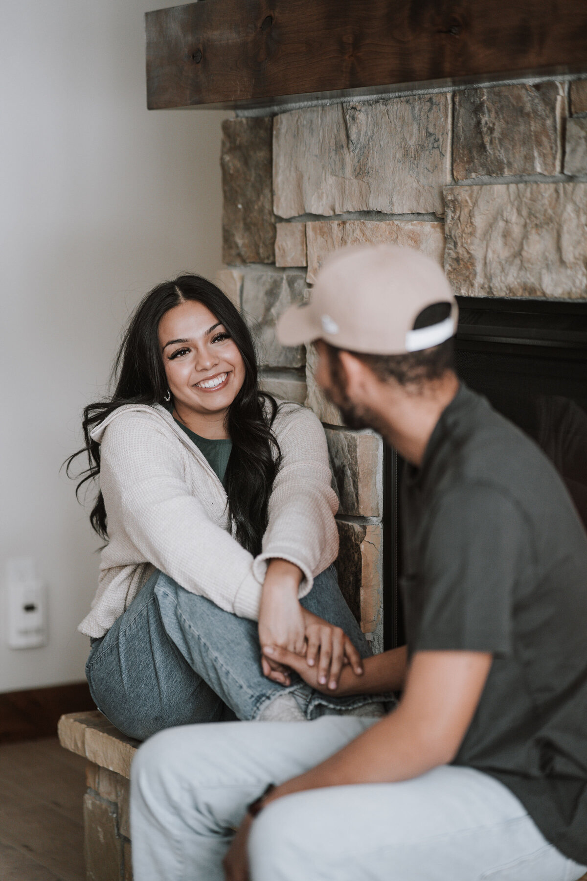 engaged couple coxy up close to the fireplace on a winter day captured by Idaho Falls Couple Photographer