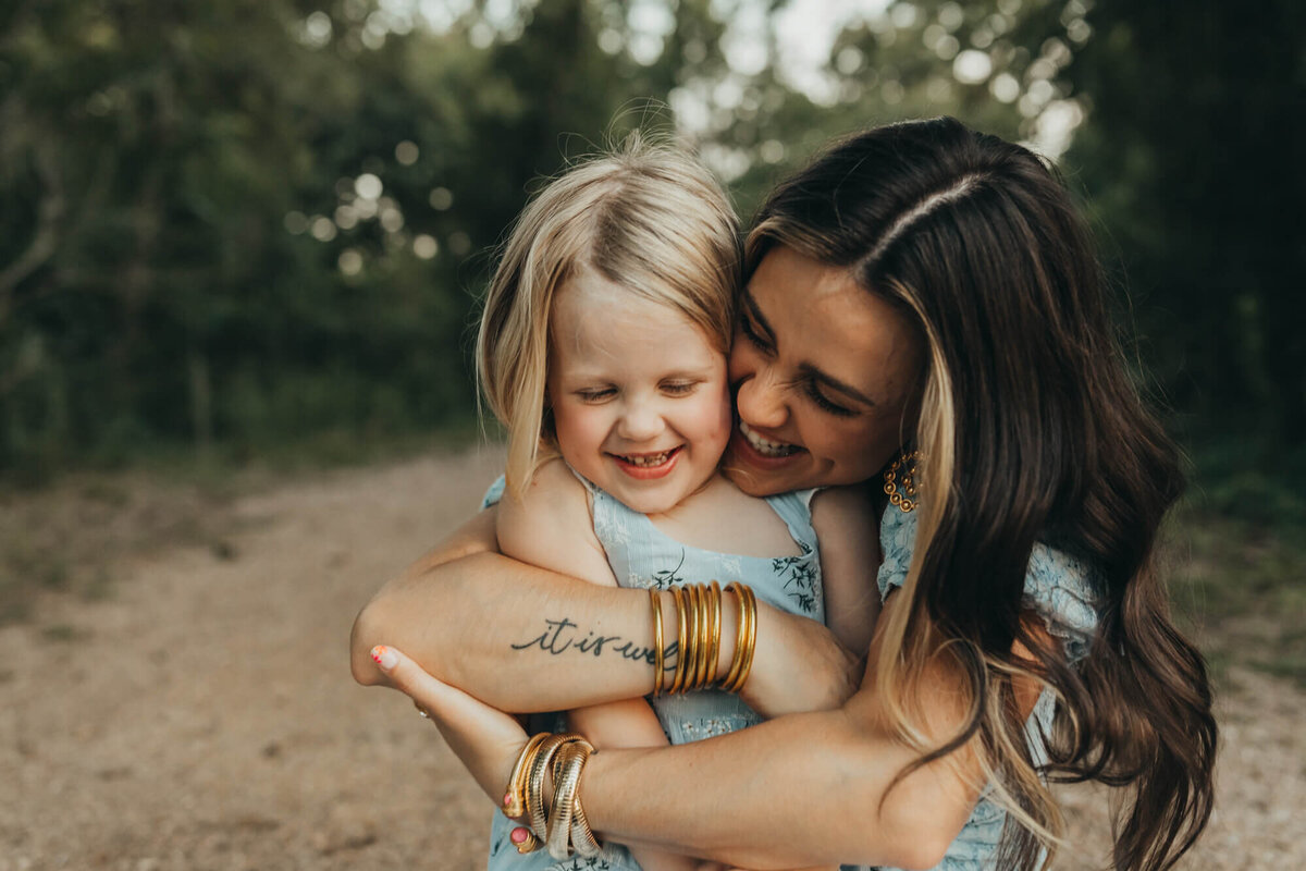 Mother holds her baby girl tight with a hug.