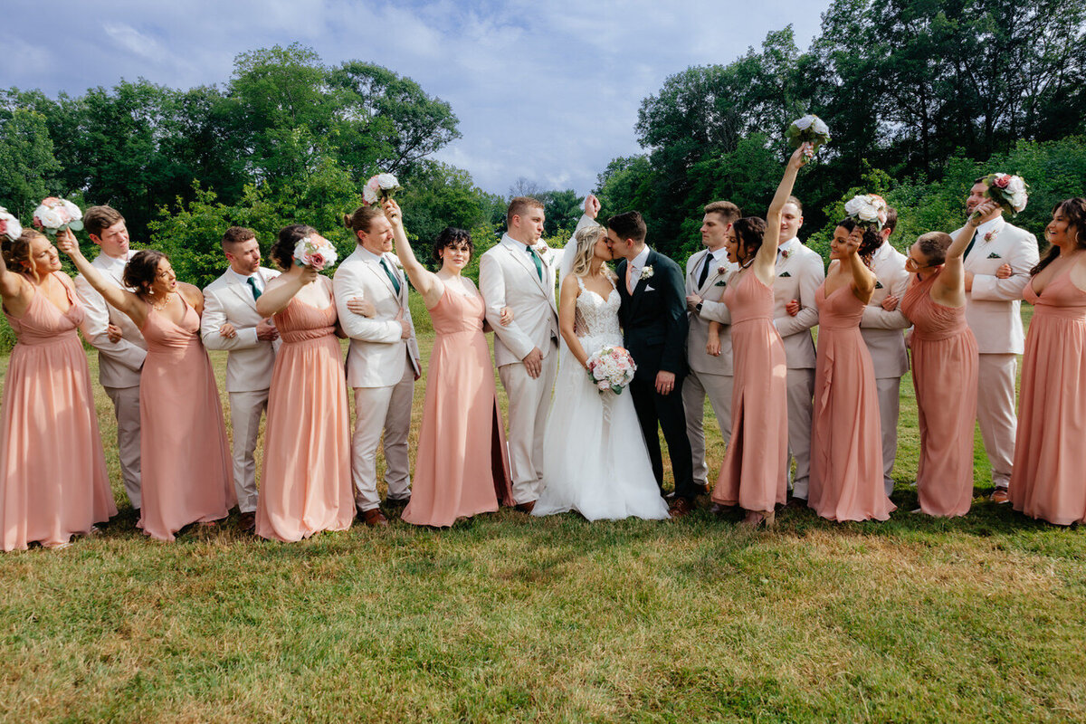 Bride and Groom and the bridal party posing together with their bouquets at Aurora Meadows.