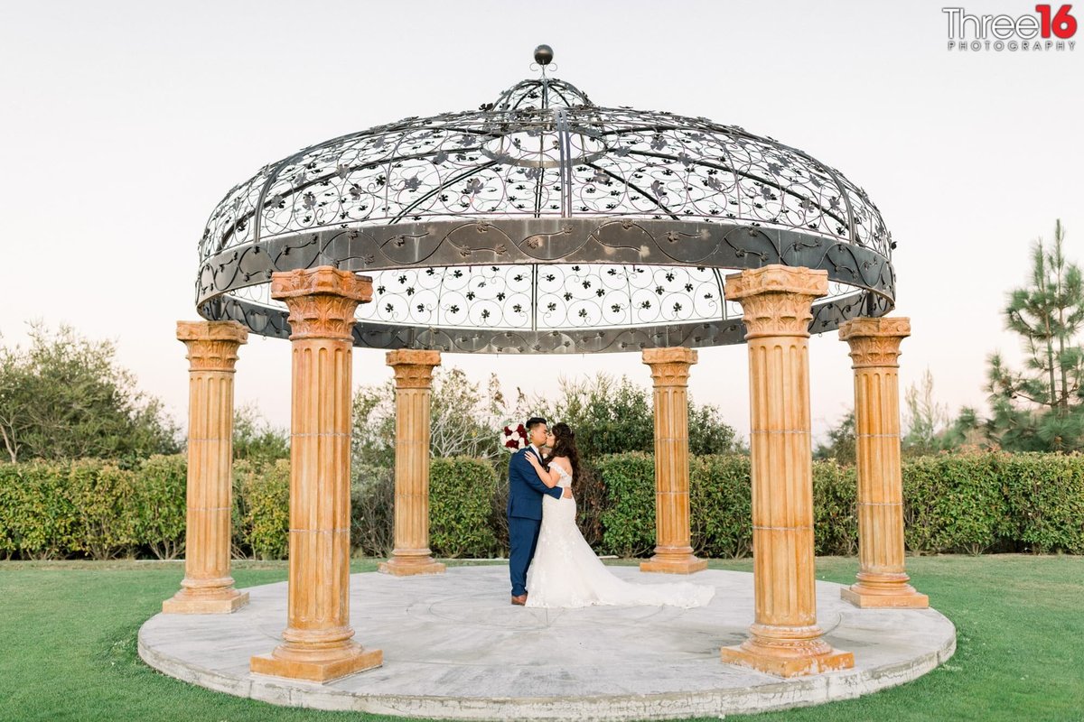 Bride and Groom share a kiss under the gazebo used for wedding ceremonies