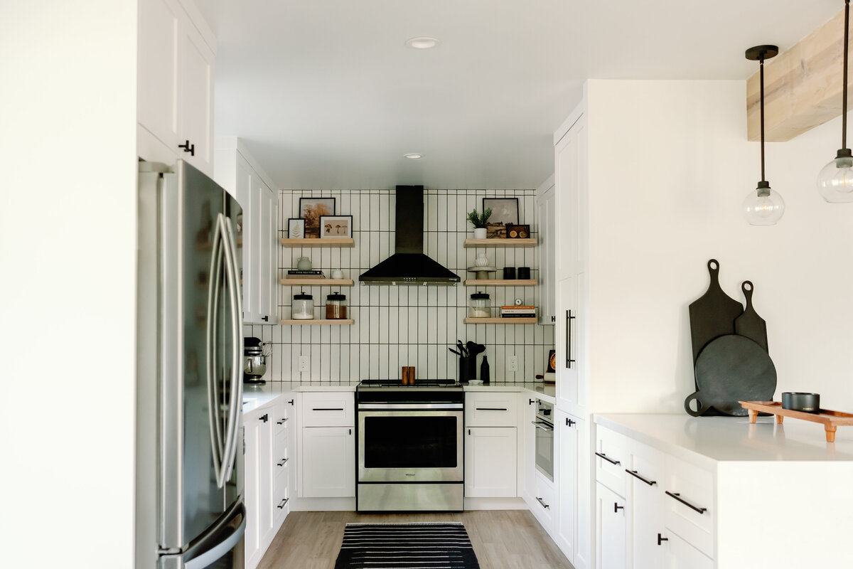 kitchen with white cabinets and white quartz countertops with white vertical stack subway tile with dark grout