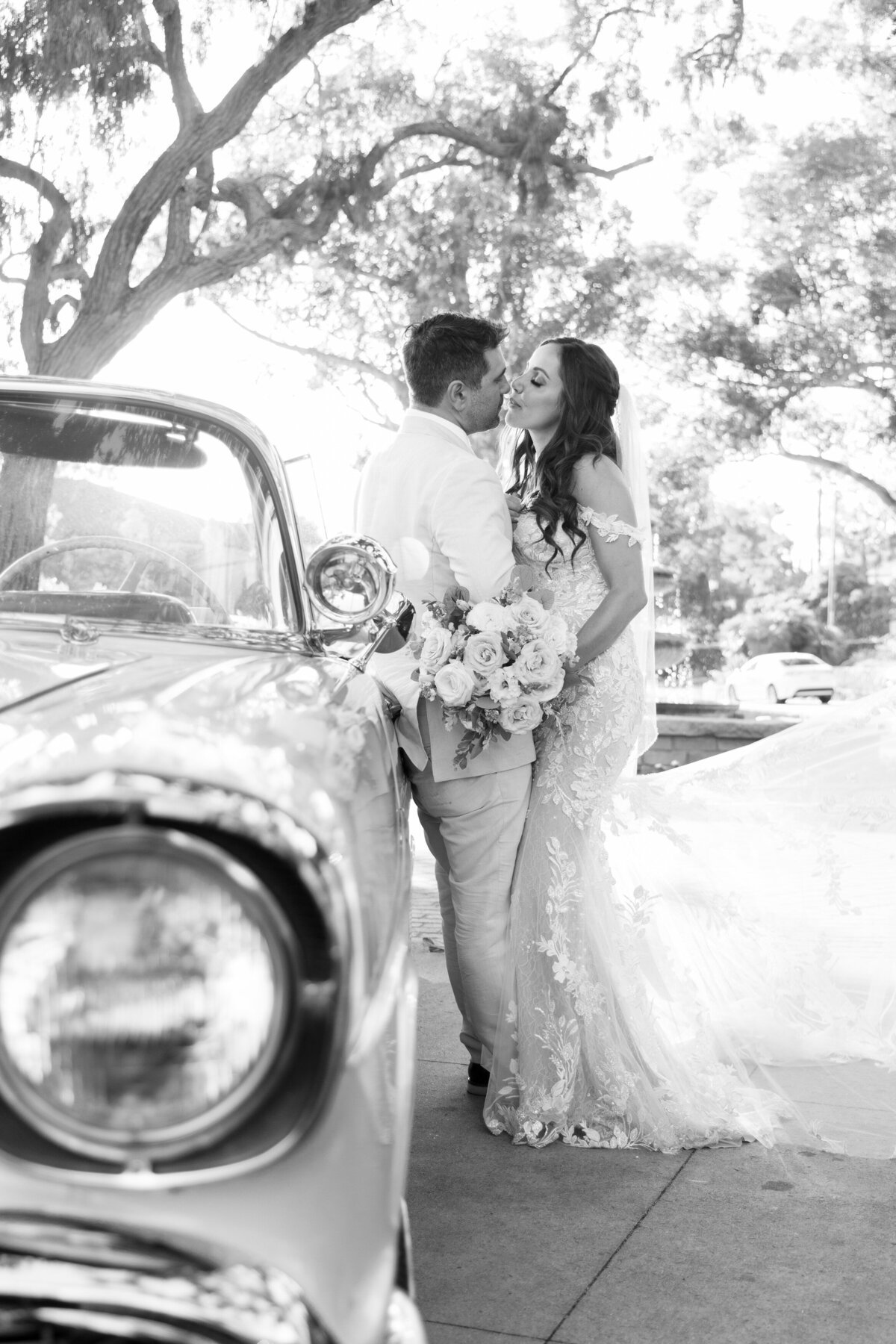 Couple standing by an antique car