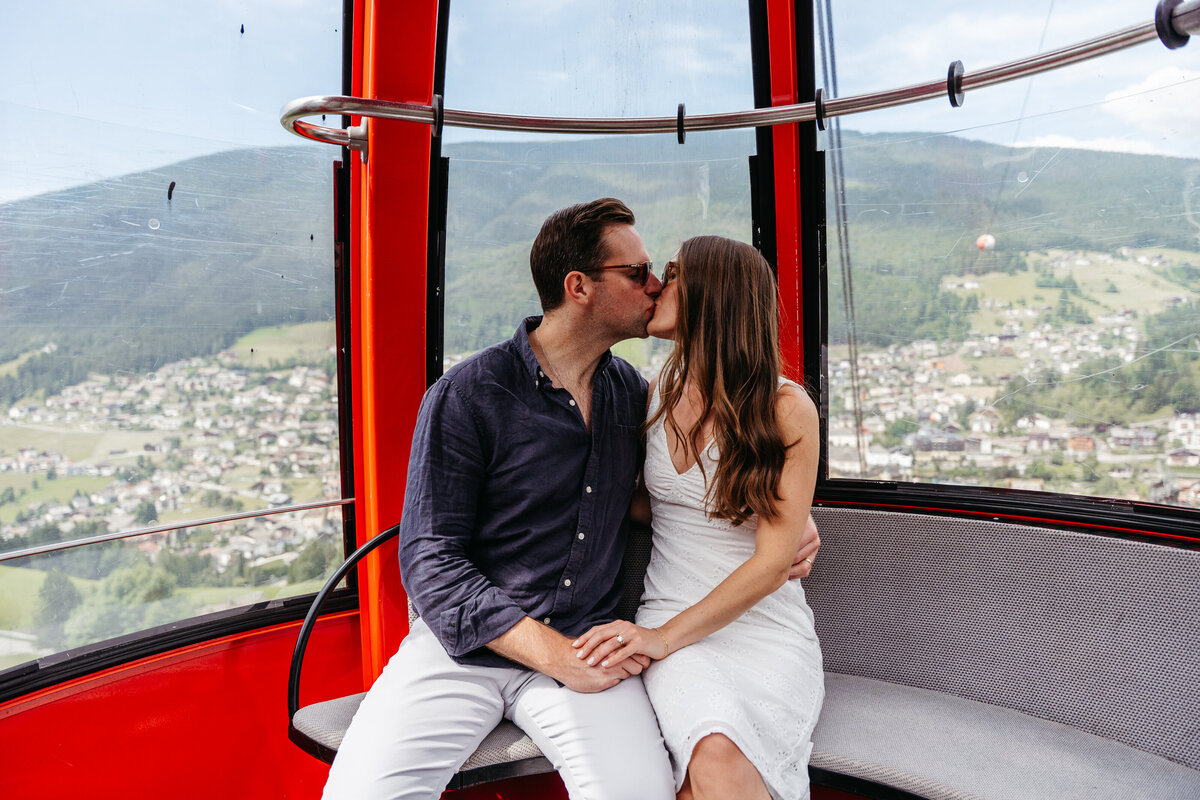 sweet couple riding gondola lift Dolomites