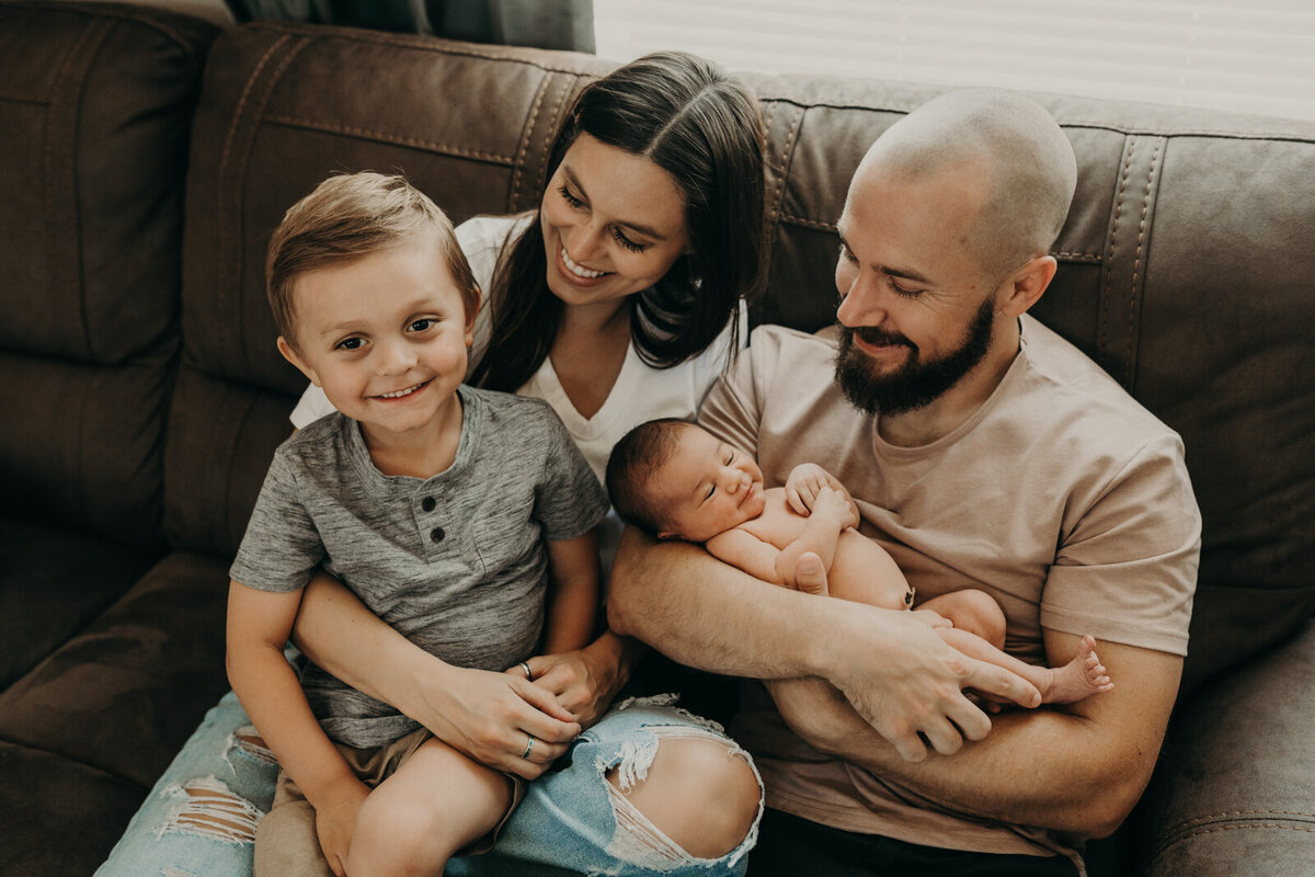 family of four in front of window looking at eachother