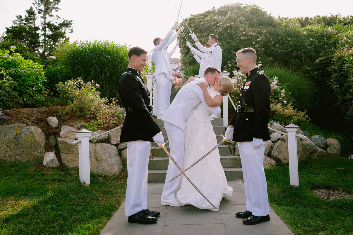 Navy sword cross in front of a couple kissing at their entrance to a Chatham Bars Inn Wedding