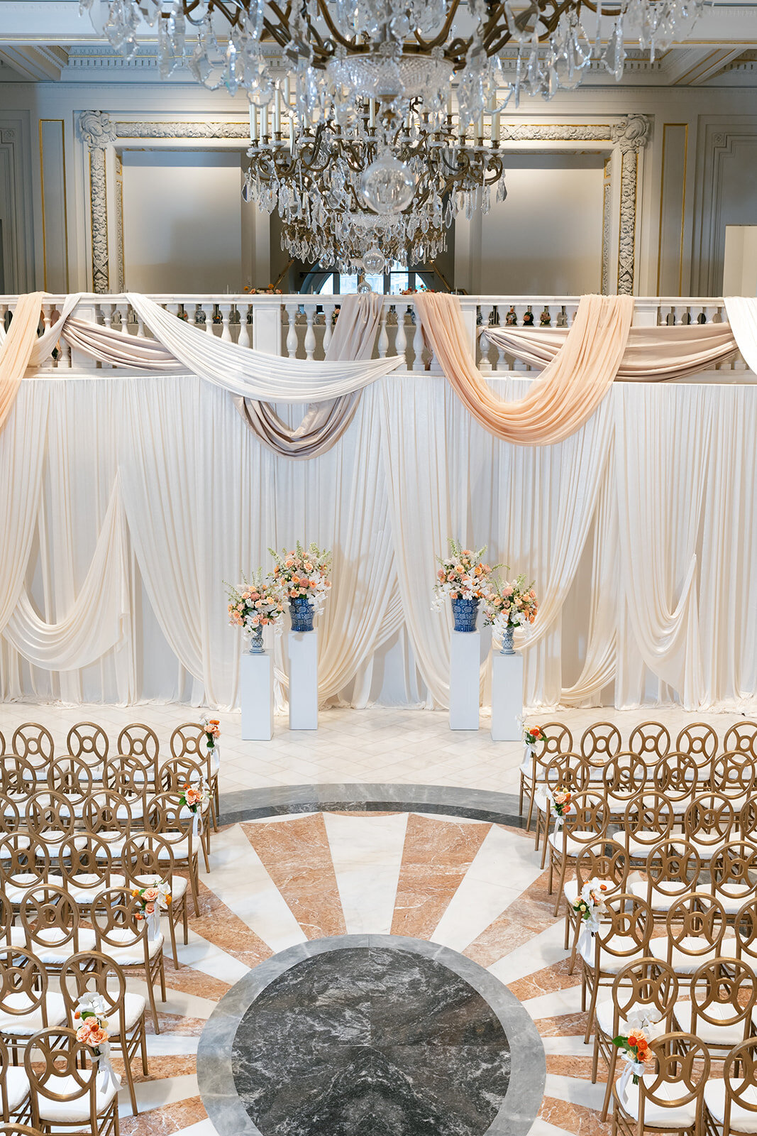Ceremony set-up in the lower mezzanine at the National Museum of Women in the Arts. Featuring textured draping and pillar arrangements of flowers. 