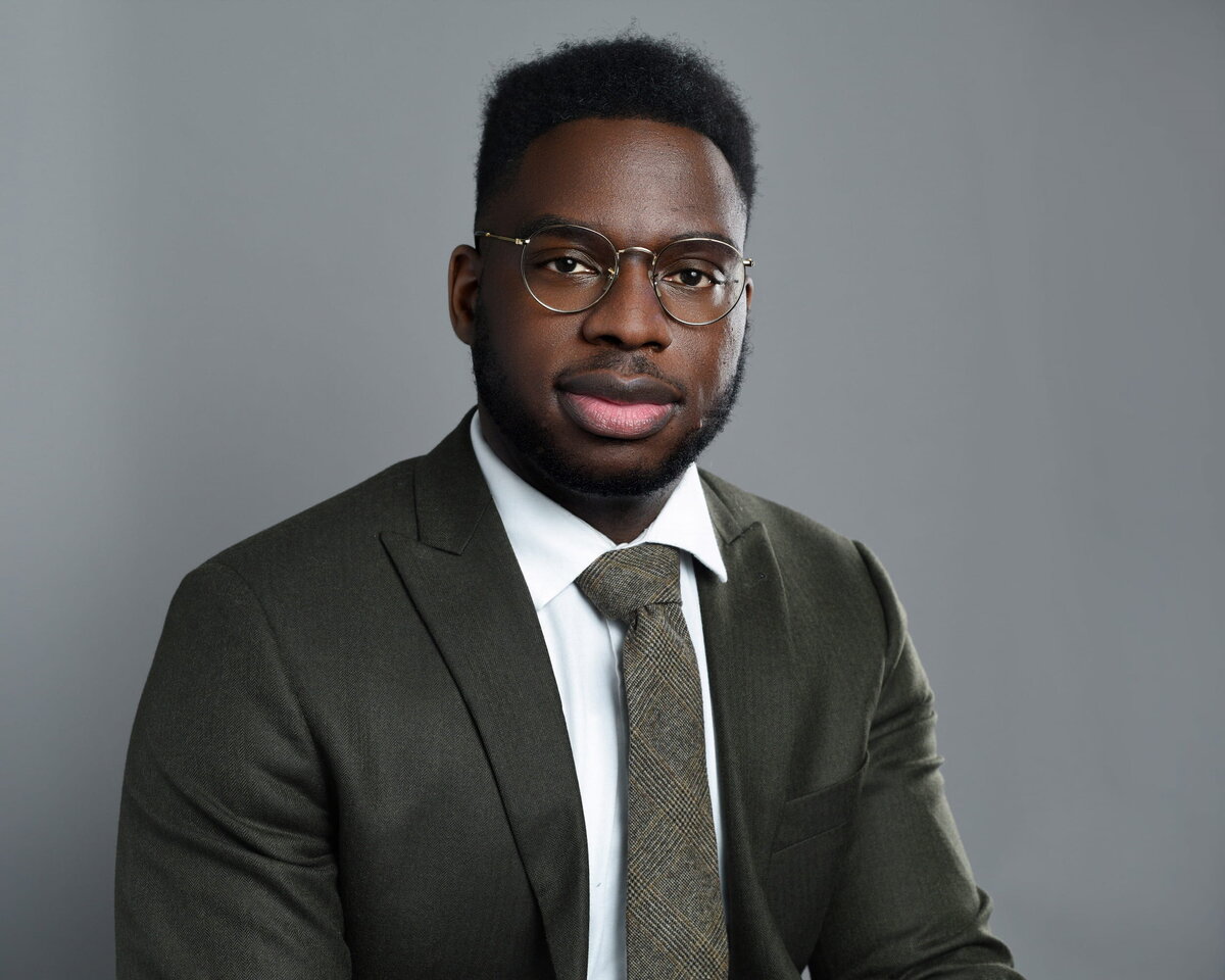 Young male tech professional in smart-casual outfit smiling in a bright studio portrait by a Toronto headshot photographer.