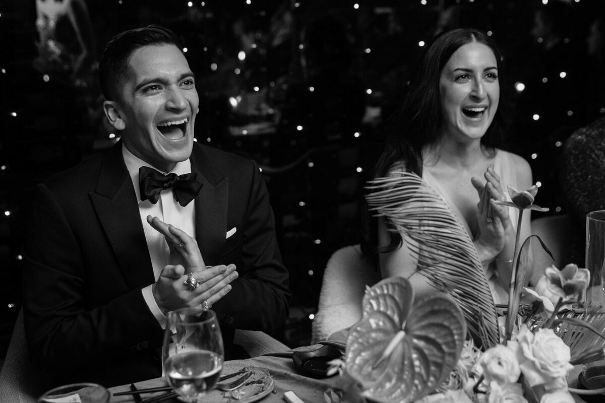 Bride and groom laughing at speeches