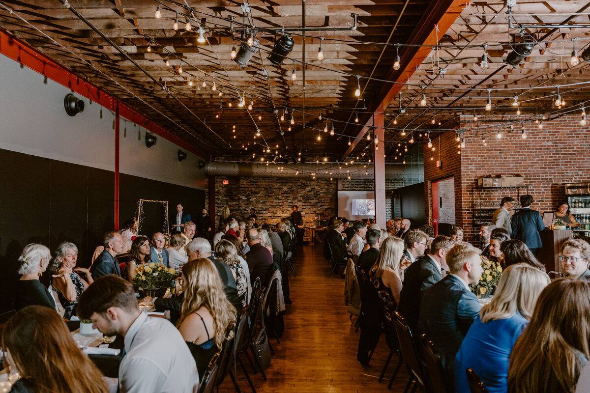 candid-guests-seated-noce-des-moines-wedding-photographer-storyteller-collective-photo-co