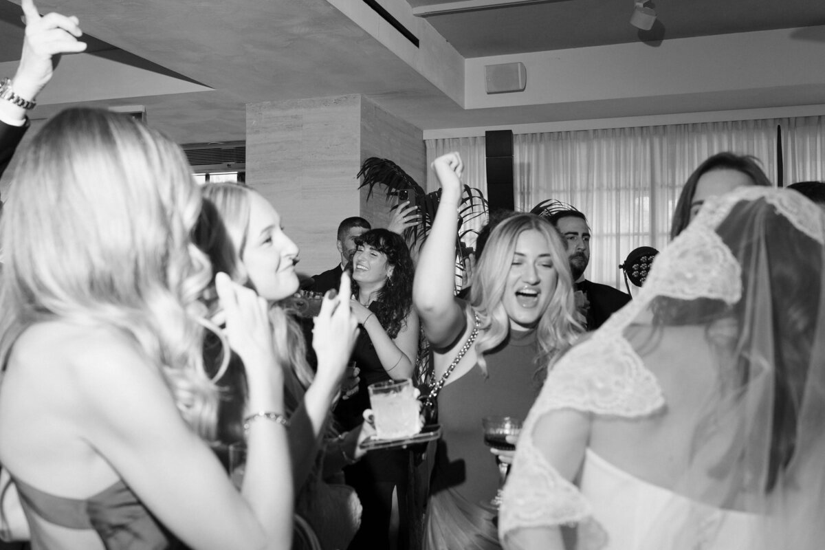 Wedding guests singing and cheering during evening celebration

