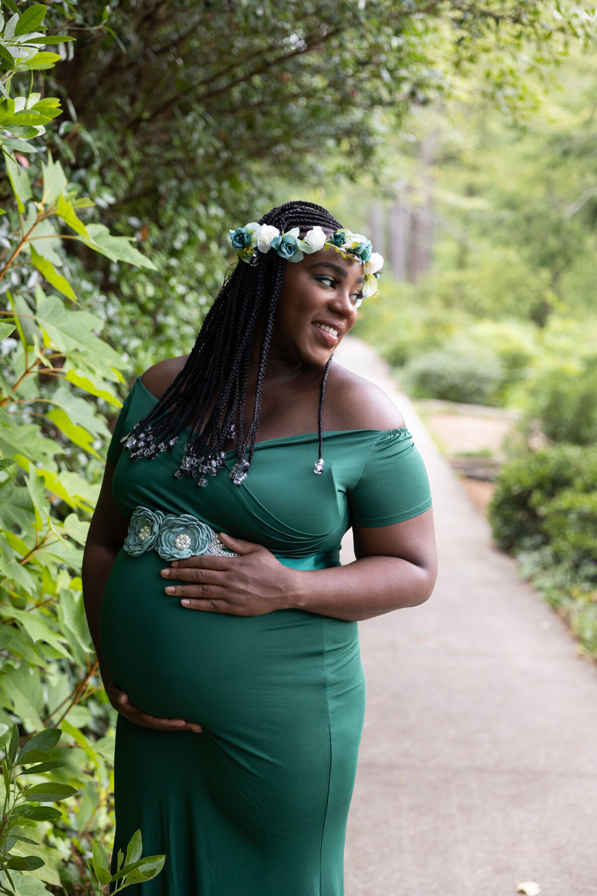 outdoor maternity of mom in green dress in park
