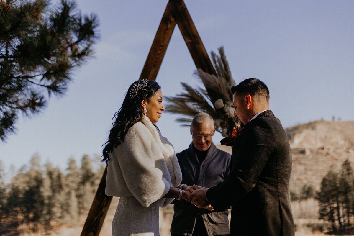 bride and groom exchanging vows in front of Fenton Lake in NM