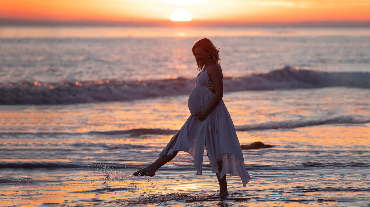 mom to be kicking the water holding baby bump taken by Los Angeles Maternity Photographer