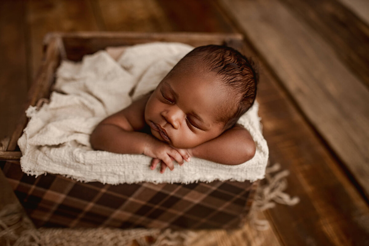 baby boy posed sleeping in crate