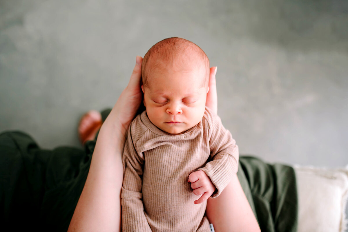 Newborn baby swaddled in a soft neutral wrap resting peacefully on a blanket, photographed by Jennifer L. Kirk Photography in Prosper, Texas. Simple and timeless newborn photography.