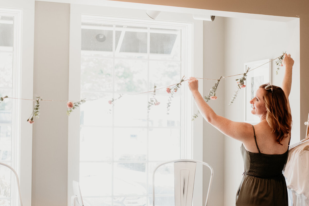 hairstylist smiling and decorating a light spacious room