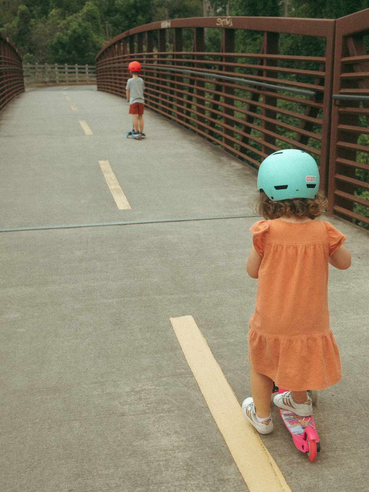 A brother and sister ride scooters at Noonday Creek Trail.