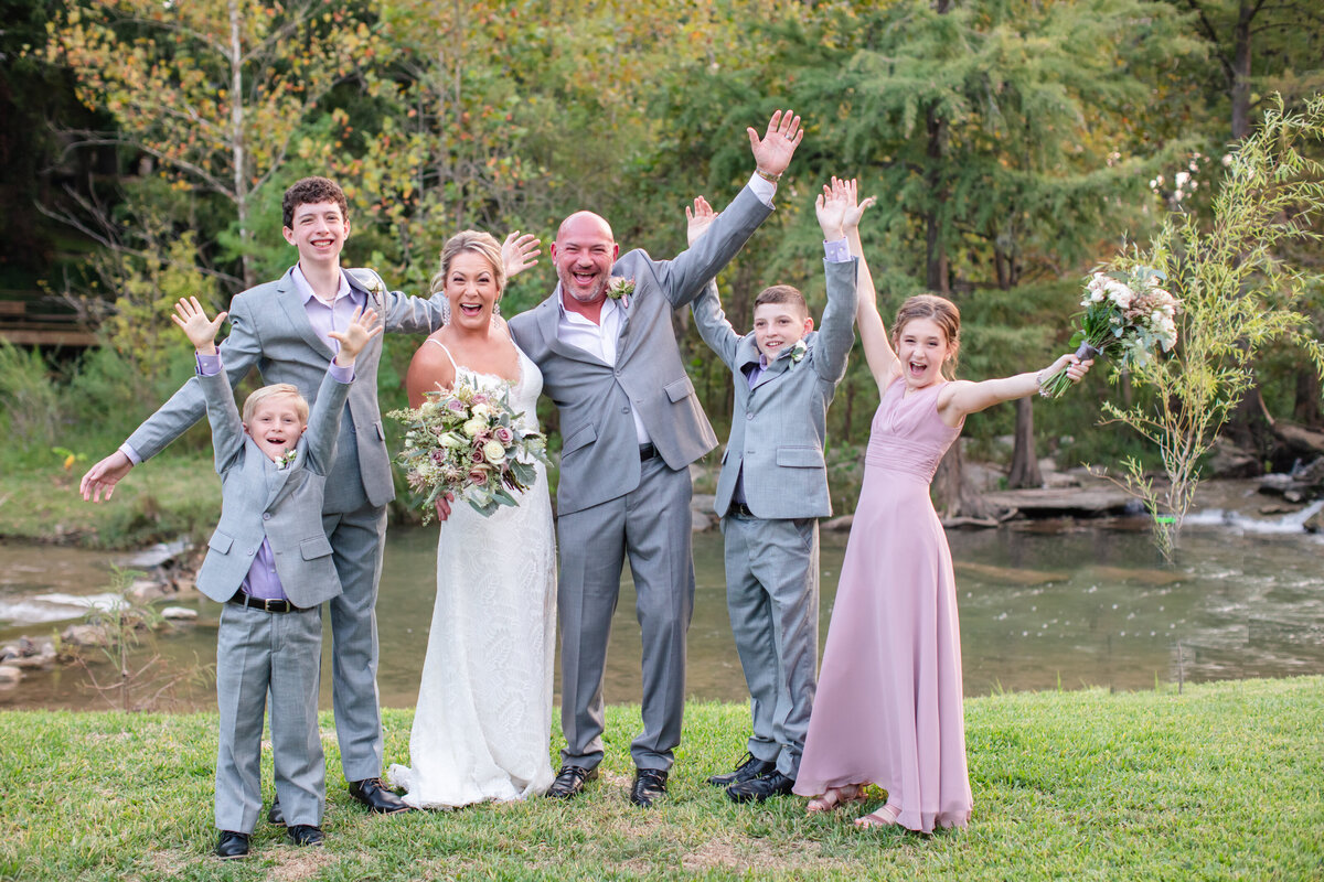 bride and groom celebrate with their four children at river wedding in New Branfels Texas