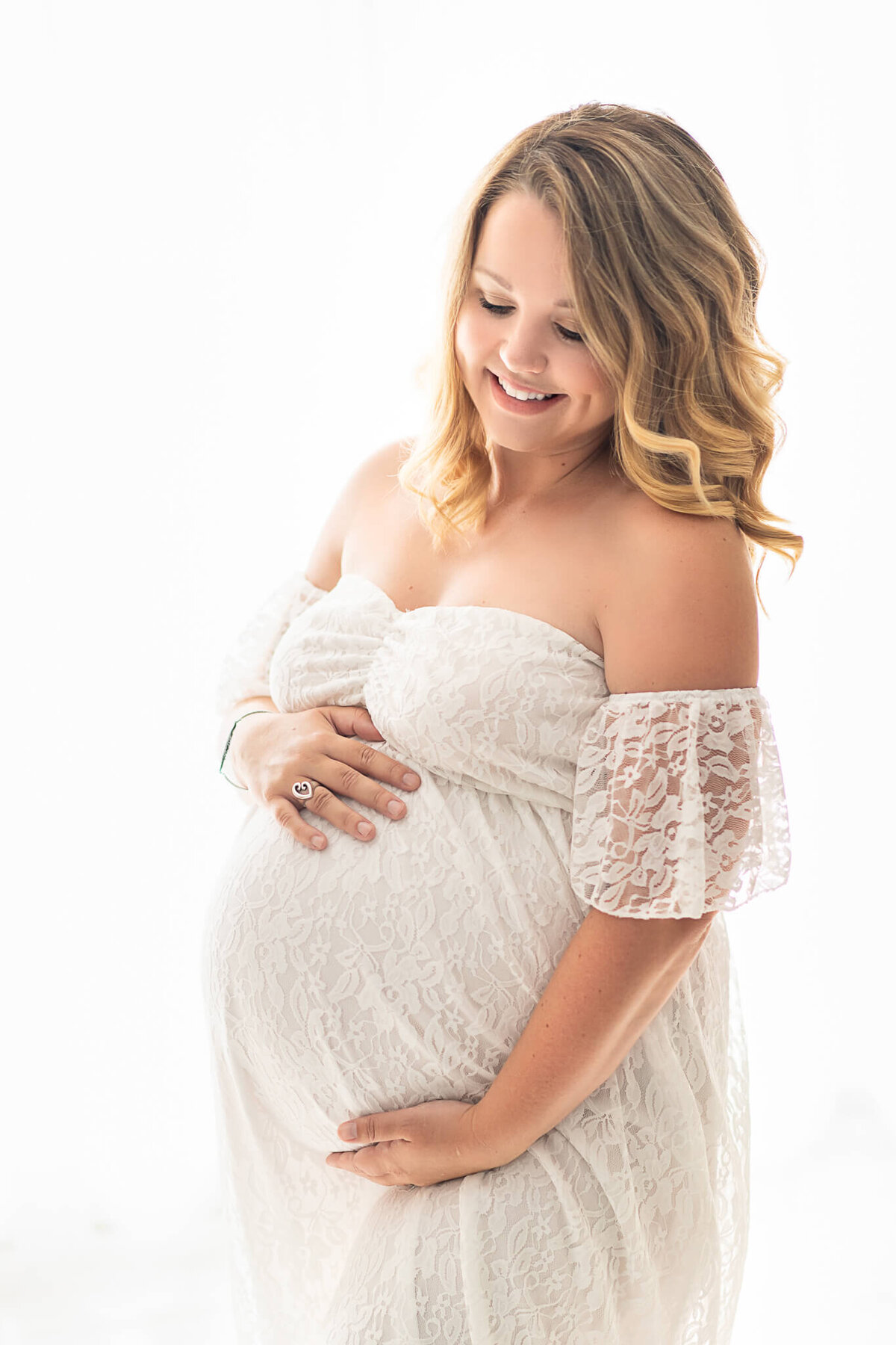 Backlit in studio maternity with mom in beautiful white gown.