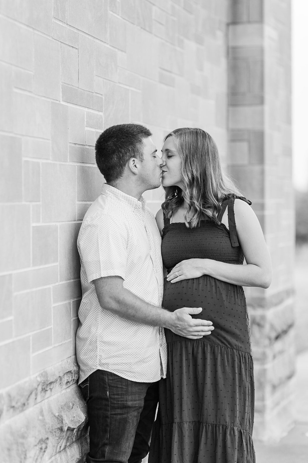 Couple kissing next t a brick wall