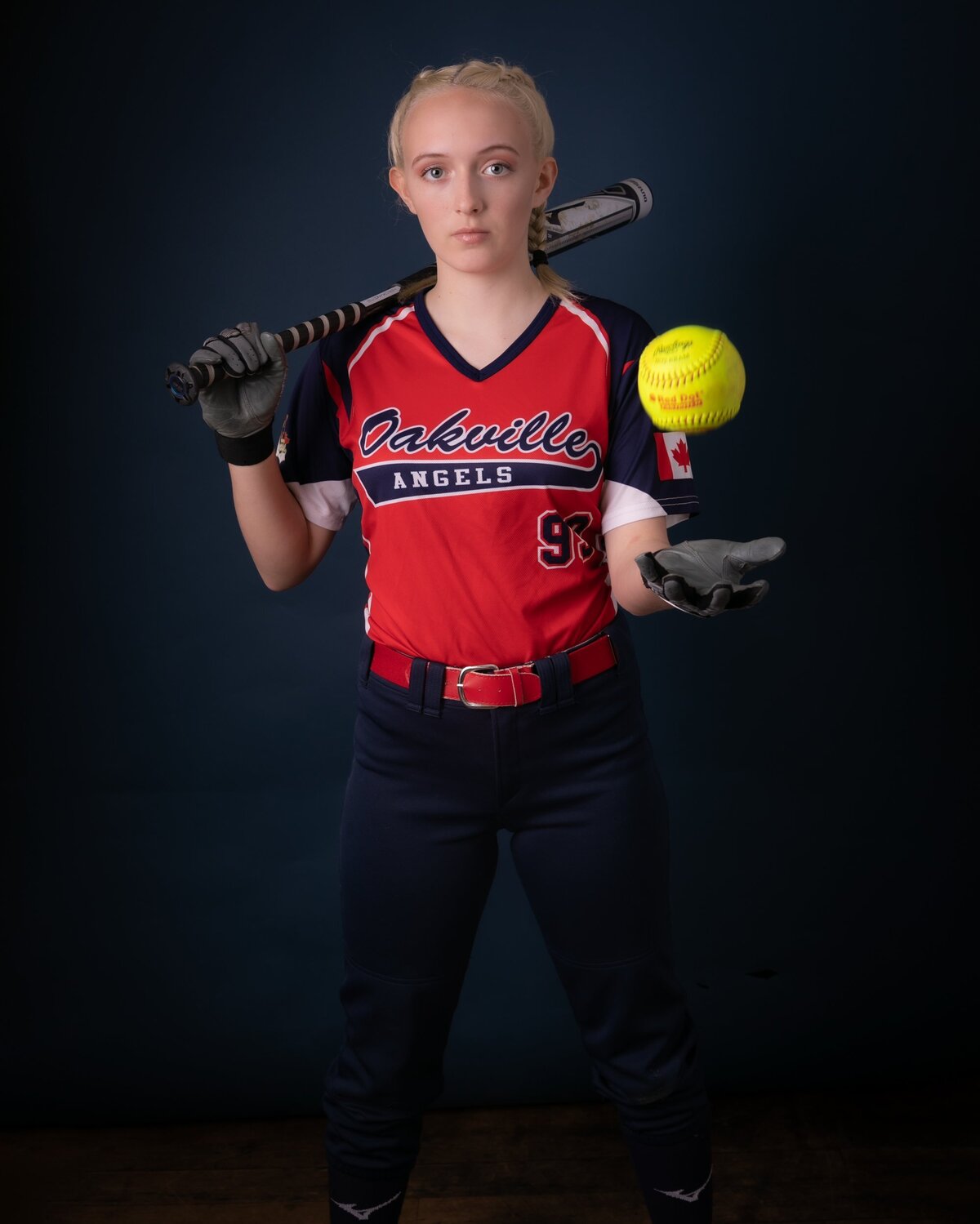 Player holding a bat and ball looking confident and strong. 