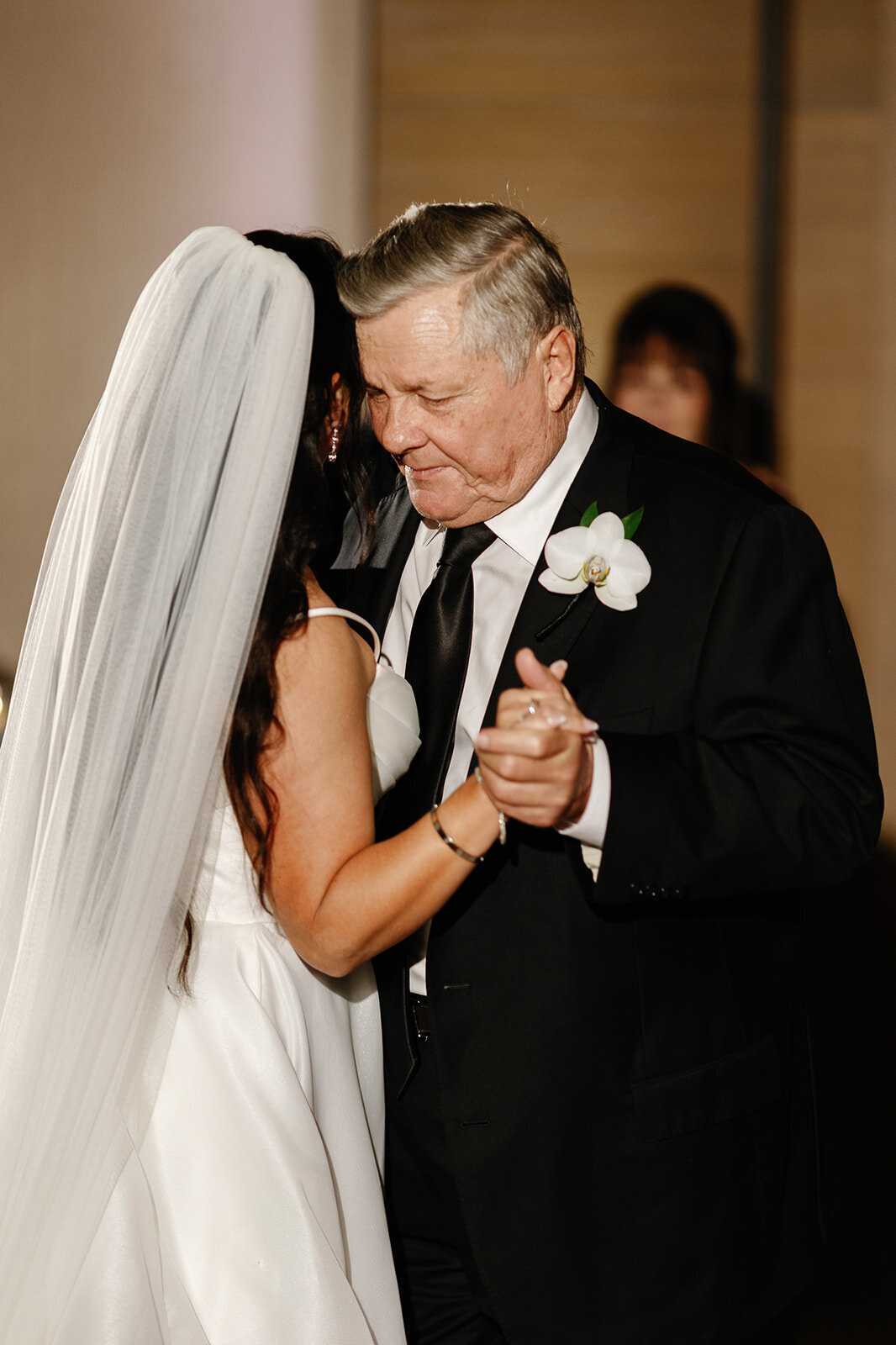 The bride shares a touching father-daughter dance, her veil gently flowing, at Ocean Reef, Key Largo.
