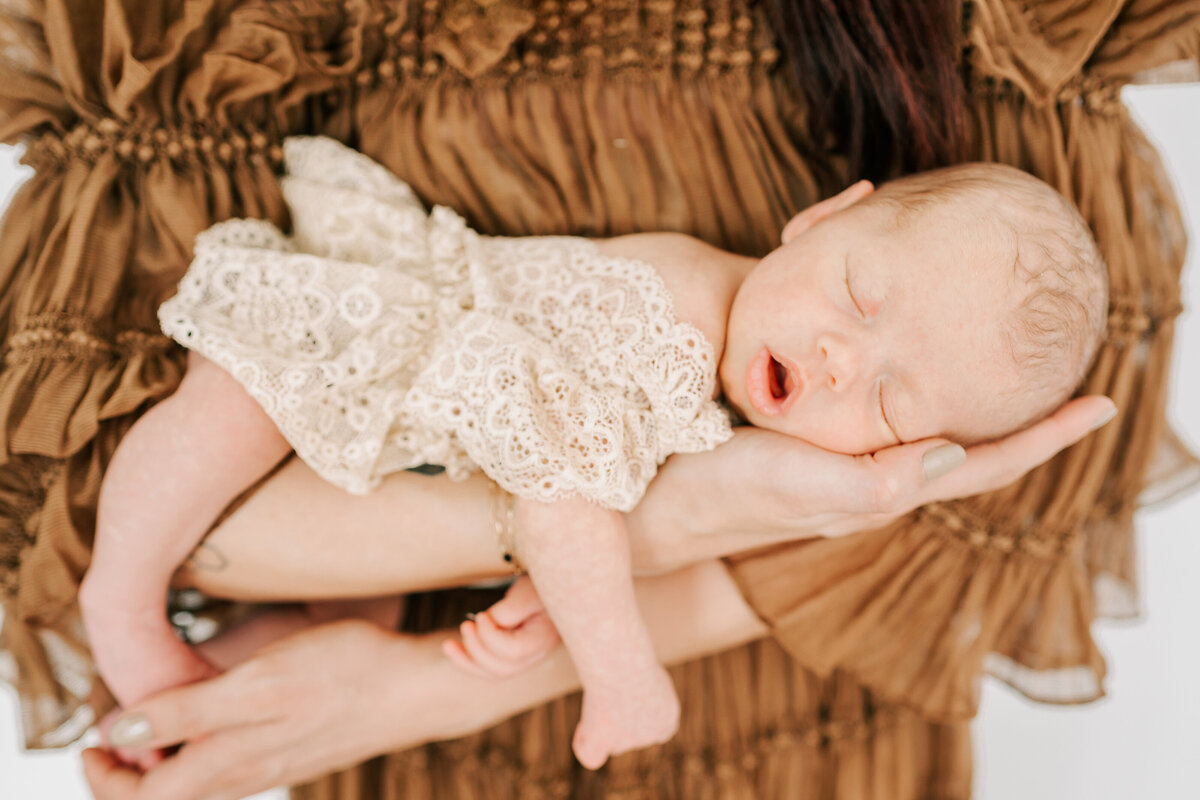 baby girl sleeping on mom shoulder during Springfield MO newborn photography studio session